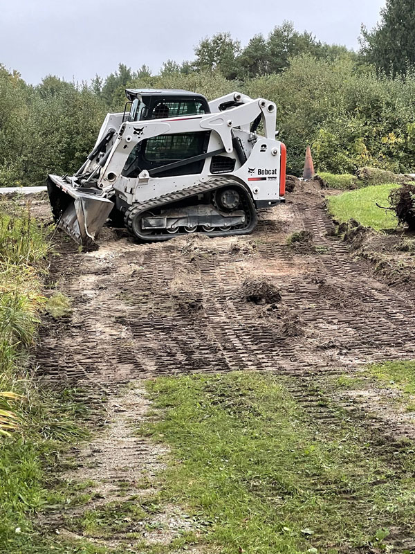 Bobcat clearing driveway area